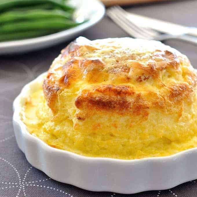 Souffle you can make ahead - freezer and refrigerator friendly. Cheesy, light as air souffl&eacute; covered in a luscious creamy sauce.