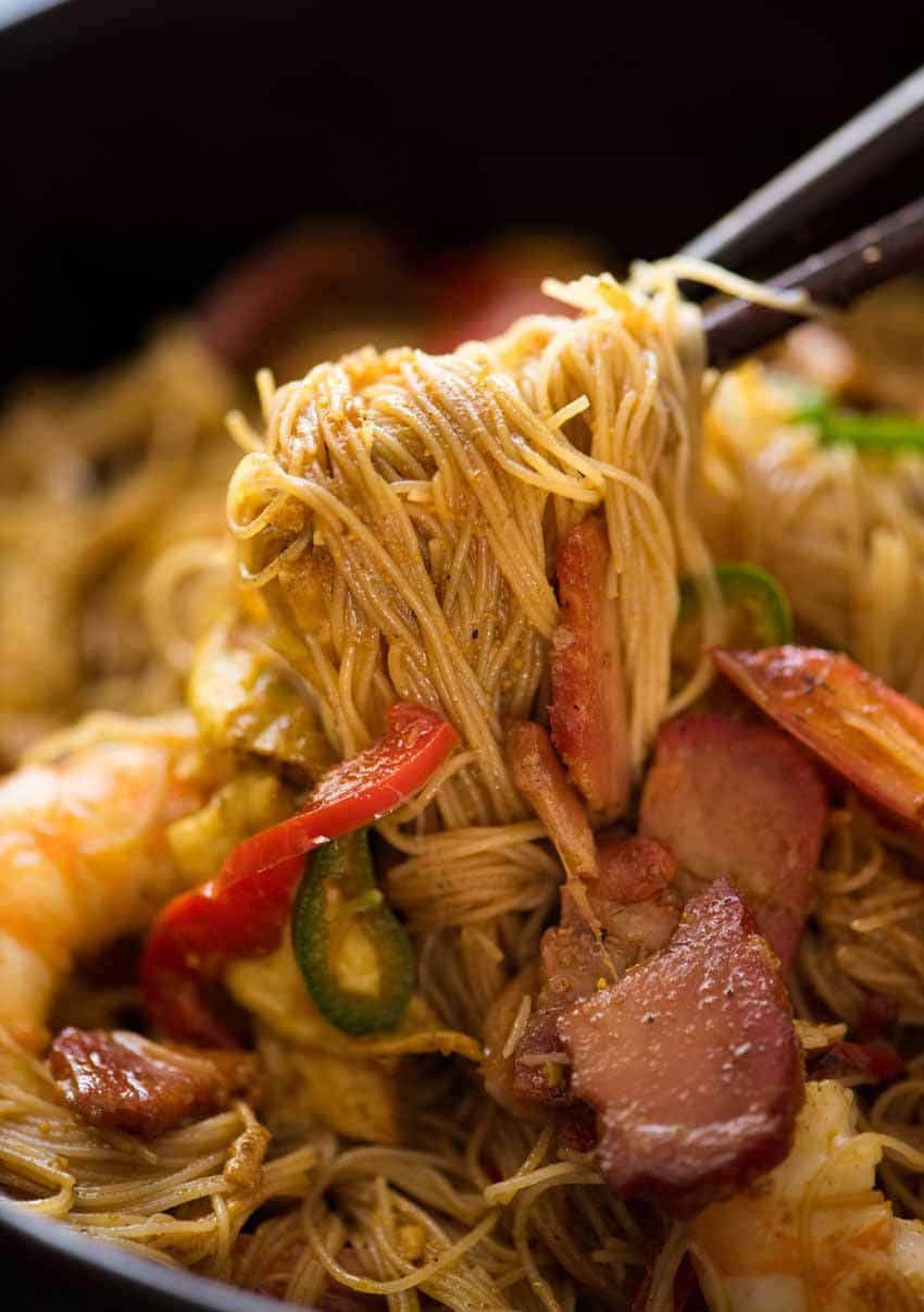 Close up of Char Siu Pork for Singapore Noodles being picked up with chopsticks
