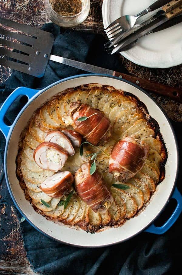 Prosciutto Wrapped Chicken and Scalloped Potatoes in a round blue casserole pan