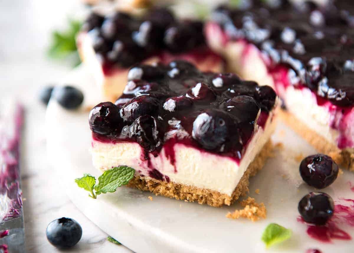 Easy and fast No Bake Blueberry Cheesecake Bars - creamy cheesecake with a gorgeous fresh blueberry sauce topping! dev.recipetineats.com