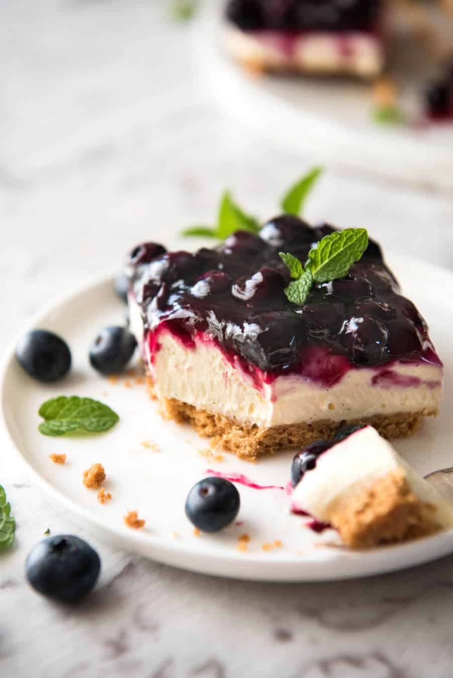 Easy and fast No Bake Blueberry Cheesecake Bars - creamy cheesecake with a gorgeous fresh blueberry sauce topping! dev.recipetineats.com