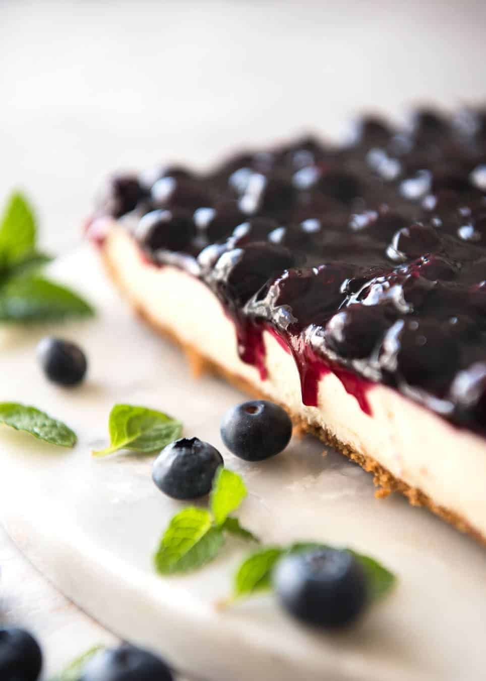 Easy and fast No Bake Blueberry Cheesecake Bars - creamy cheesecake with a gorgeous fresh blueberry sauce topping! dev.recipetineats.com