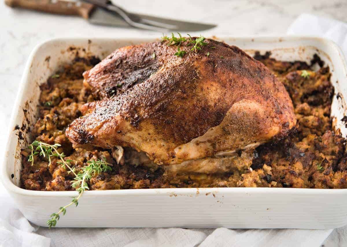 This Cajun dry brined turkey breast is baked in the same roasting pan as the Dressing / Stuffing so it's extra juicy and moist! A chef recipe, this Cajun Baked Turkey Breast with Dressing is easy and spectacular. EPIC ONE PAN COOKING for a Thanksgiving turkey! dev.recipetineats.com