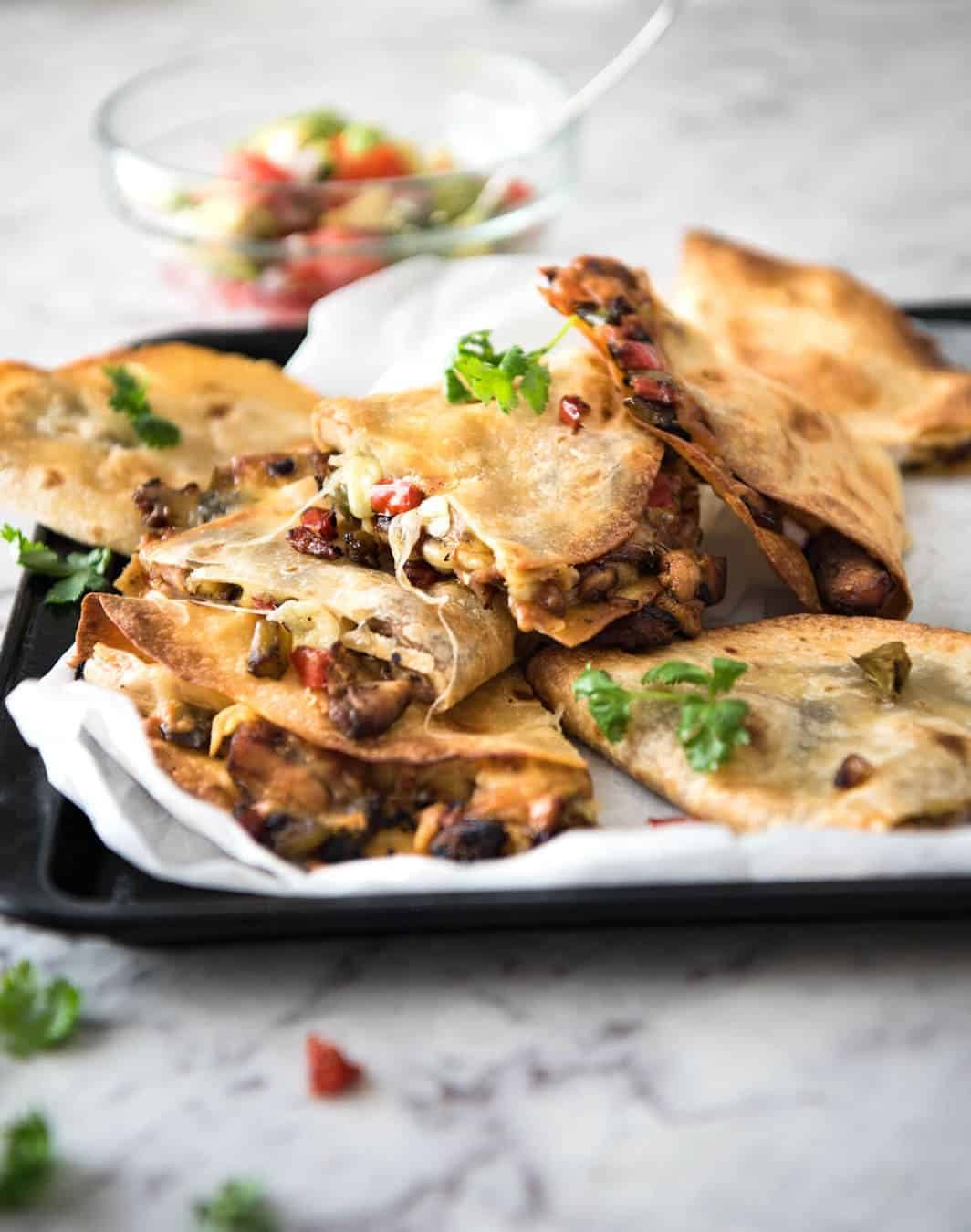 Crispy Oven Baked Chicken Quesadillas - This is how to make multiple Quesadillas at the same time! Crispy on the outside, stuffed with Mexican seasoned chicken and capsicum / bell peppers (and cheese of course!) dev.recipetineats.com