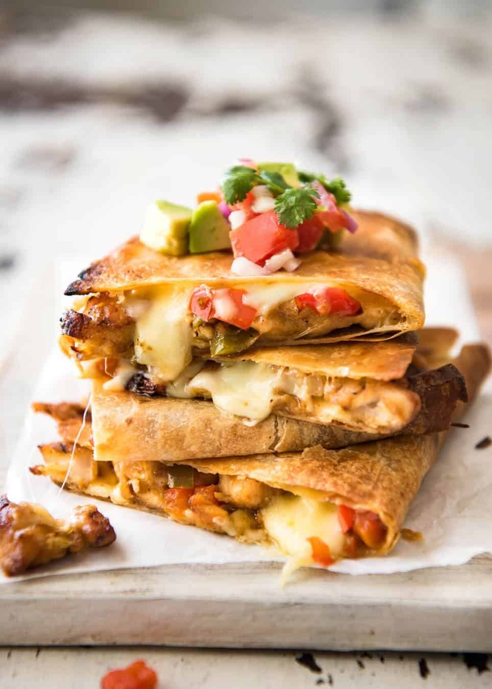 Crispy Oven Baked Chicken Quesadillas - This is how to make multiple Quesadillas at the same time! Crispy on the outside, stuffed with Mexican seasoned chicken and capsicum / bell peppers (and cheese of course!) dev.recipetineats.com