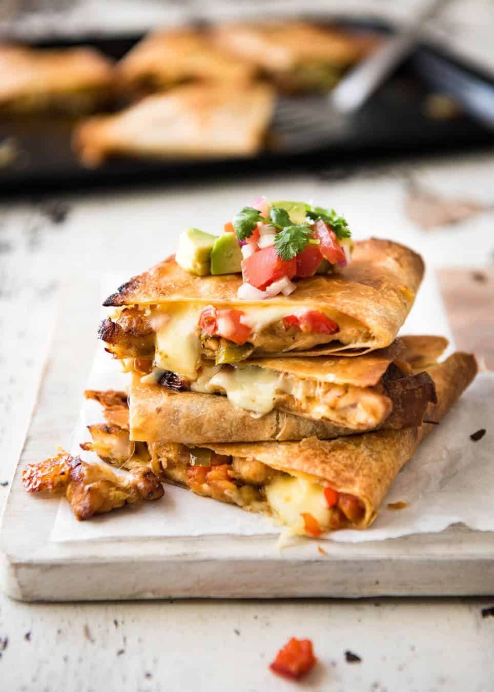 Crispy Oven Baked Chicken Quesadillas - This is how to make multiple Quesadillas at the same time! Crispy on the outside, stuffed with Mexican seasoned chicken and capsicum / bell peppers (and cheese of course!) dev.recipetineats.com