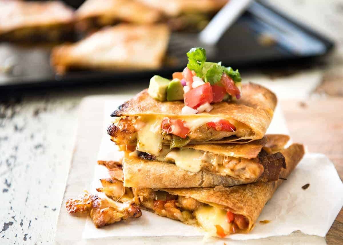 Crispy Oven Baked Chicken Quesadillas - This is how to make multiple Quesadillas at the same time! Crispy on the outside, stuffed with Mexican seasoned chicken and capsicum / bell peppers (and cheese of course!) dev.recipetineats.com