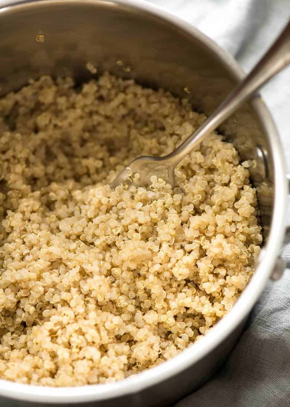 Cooked fluffy quinoa in a silver saucepan.