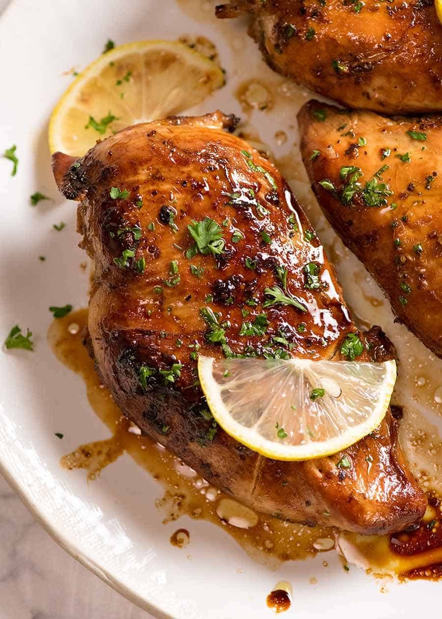 Cooked chicken breast (after marinated in Chicken Marinade) on a white plate, ready to be served