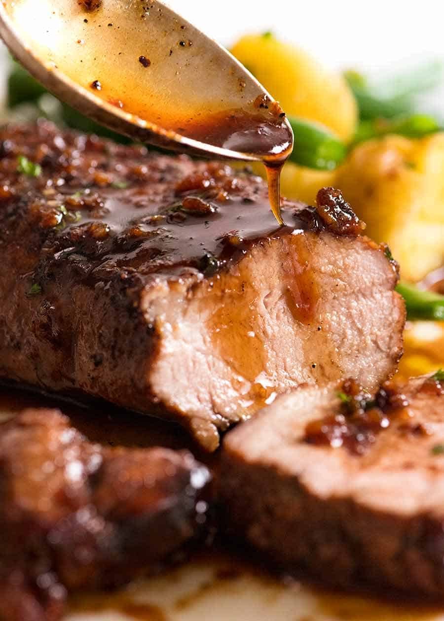 Spoon drizzling Honey Garlic Sauce over pork tenderloin