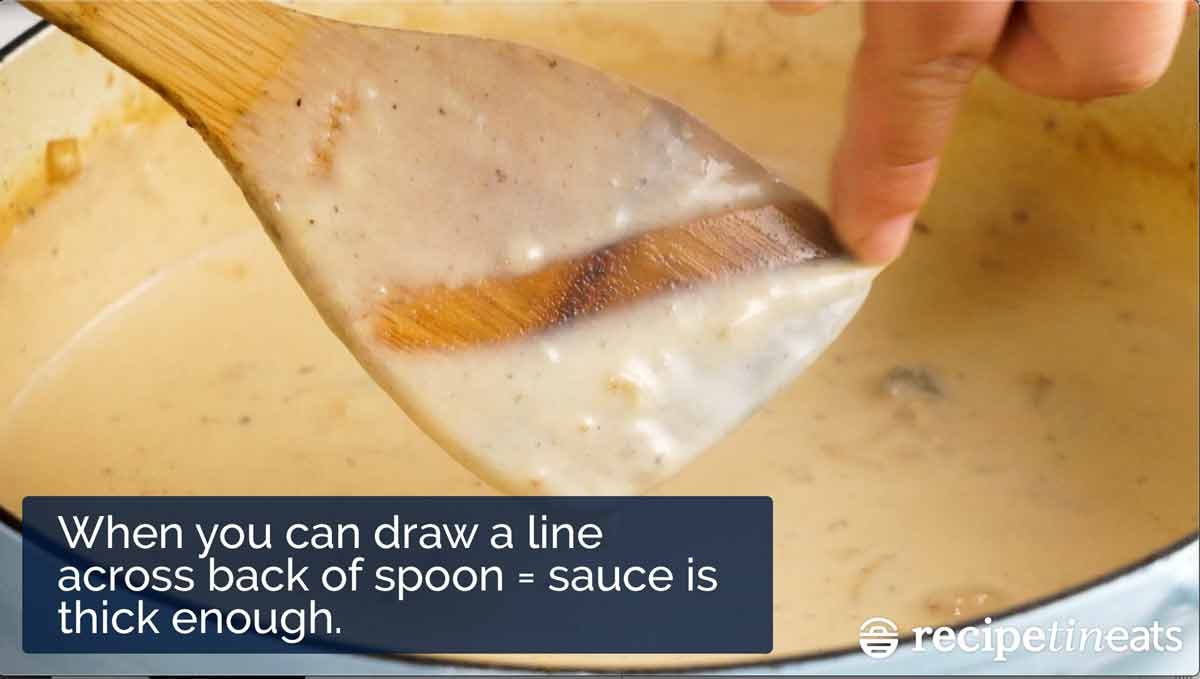 Drawing a line across the spoon to check thickness of b&eacute;chamel sauce