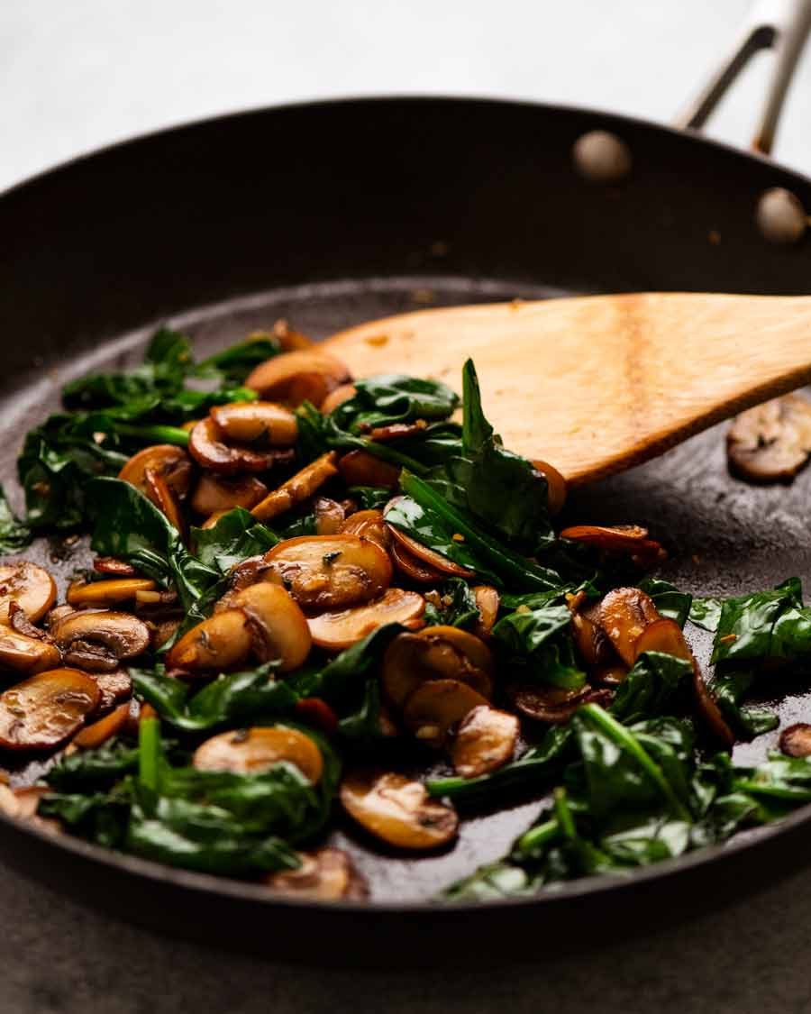 Skillet with saut&eacute;ed mushrooms and spinach